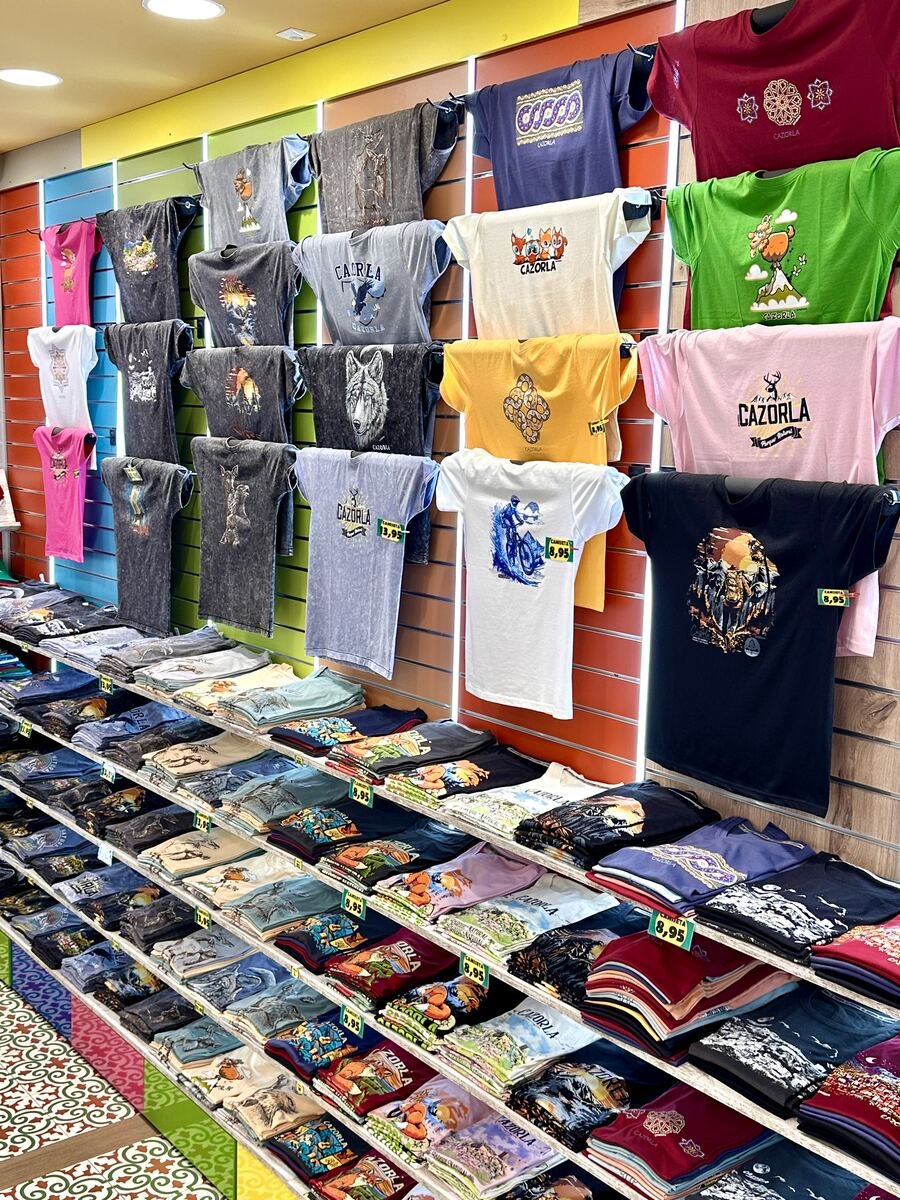 Pared de camisetas de diseño propio en la tienda de Cazorla