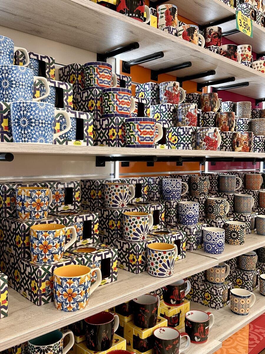 Estantería de tazas con dibujos de azulejo en la tienda de Ronda