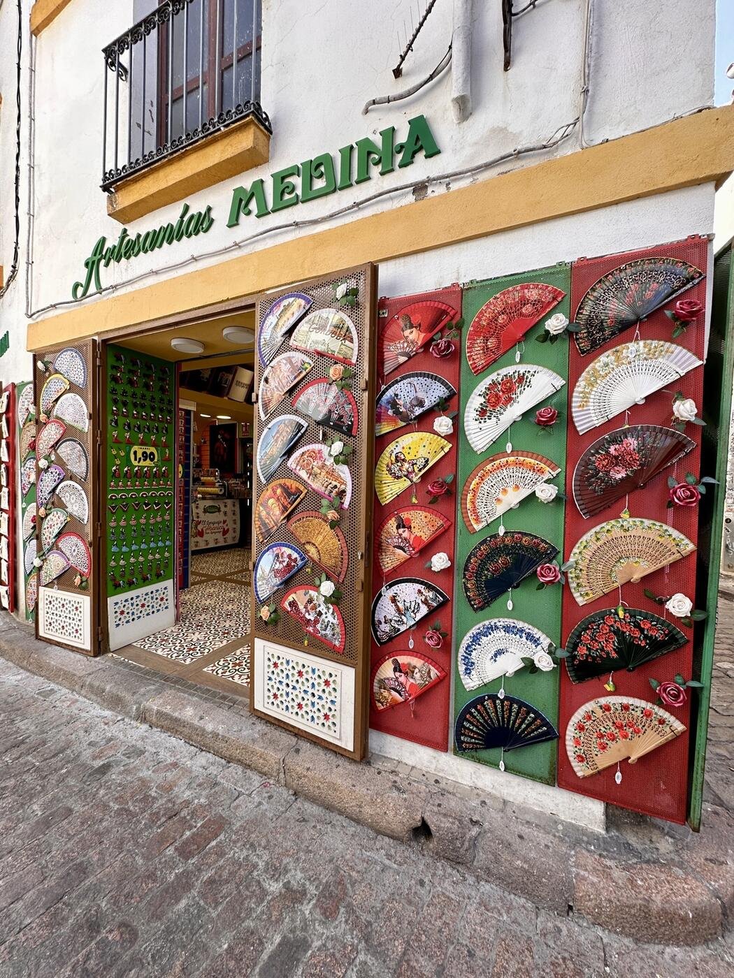 Fachada de Artesanías Medina en la calle Romero de Córdoba, con su pared de abanicos
